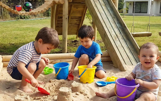 Niños jugando y haciendo castillos con arena limpia Cimic en un arenero