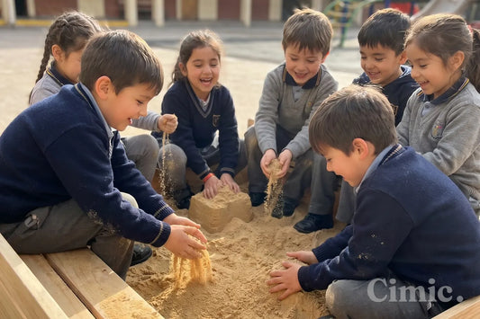 Niños de colegio con uniforme jugando en un arenero con arena limpia durante el recreo en Santiago