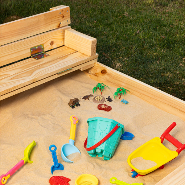 Arena para niños dentro de un arenero de madera, con palas y baldes