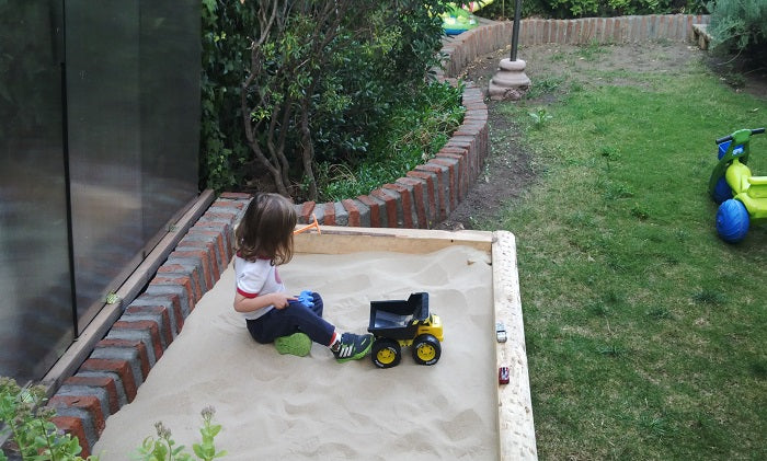 Niños jugando en arenero con arena limpia para juegos infantiles en Santiago. Arena 25kg harneada y lavada, sin impurezas. Cimic, venta de arena para areneros en Santiago – cimic.cl