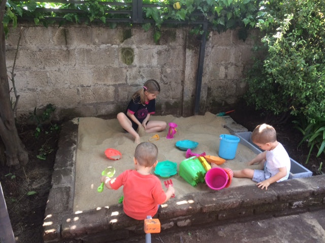 Niños jugando en arenero con arena limpia para juegos infantiles en Santiago. Arena 25kg harneada y lavada, sin impurezas. Cimic, venta de arena para areneros en Santiago – cimic.cl
