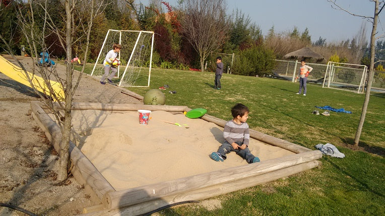 Niños jugando en arenero con arena limpia para juegos infantiles en Santiago. Arena 25kg harneada y lavada, sin impurezas. Cimic, venta de arena para areneros en Santiago – cimic.cl