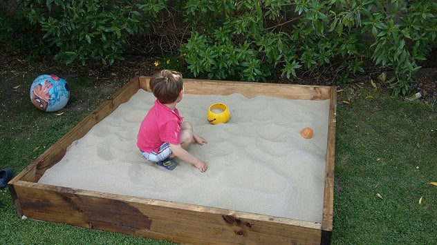 Niños jugando en arenero con arena limpia para juegos infantiles en Santiago. Arena 25kg harneada y lavada, sin impurezas. Cimic, venta de arena para areneros en Santiago – cimic.cl