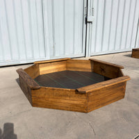 Arenero de madera octogonal para niños de 150 cm de diámetro visto de frente, con cuatro asientos en el borde