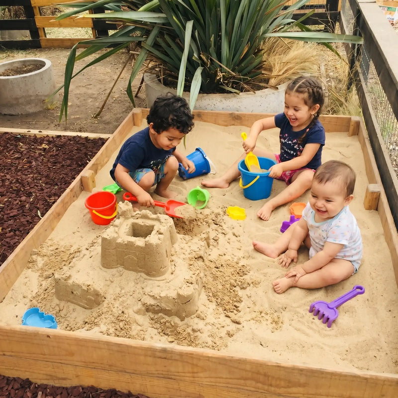 Niños jugando en arenero con arena limpia para juegos infantiles en Santiago. Arena 25kg harneada y lavada, sin impurezas. Cimic, venta de arena para areneros en Santiago – cimic.cl