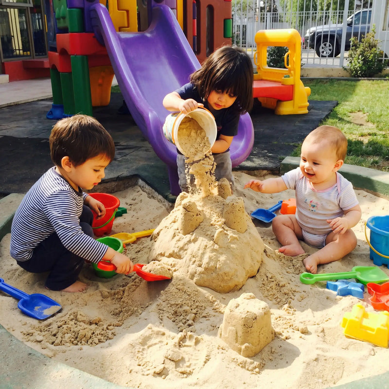 Niños jugando en arenero con arena limpia para juegos infantiles en Santiago. Arena 25kg harneada y lavada, sin impurezas. Cimic, venta de arena para areneros en Santiago – cimic.cl