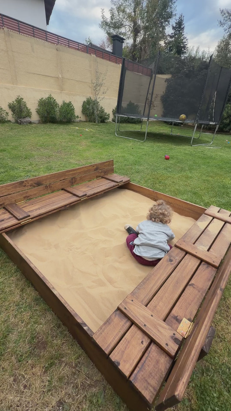 Niño jugando en el arenero de madera de 150 × 150 cm con bancas — video